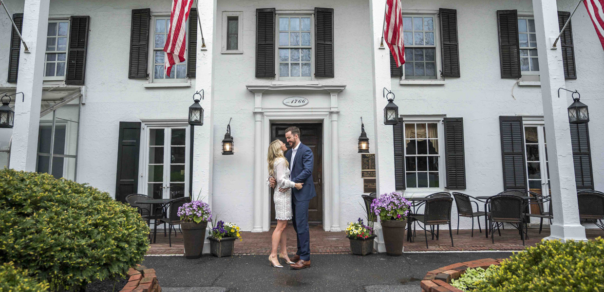 photo of couple embracing in front of Beekman Arms