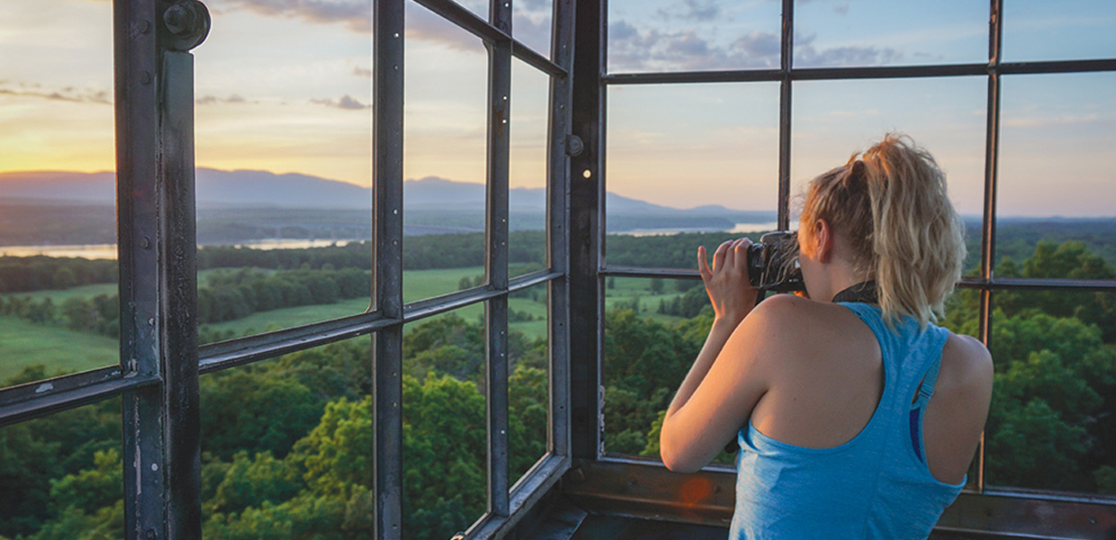 photo of woman photographing sunset in Ferncliff Fire Tower